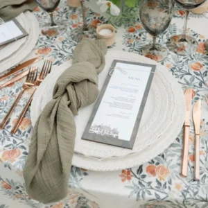 An elegant table setting with a Callie Olive Napkin and silverware available for event linen rental.