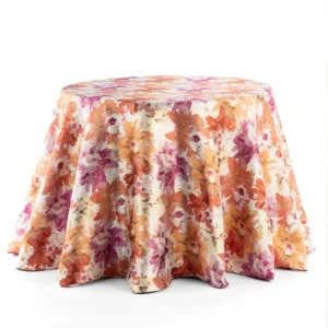 A round table draped in Penelope Pomegranate fabric available for event linen rental.