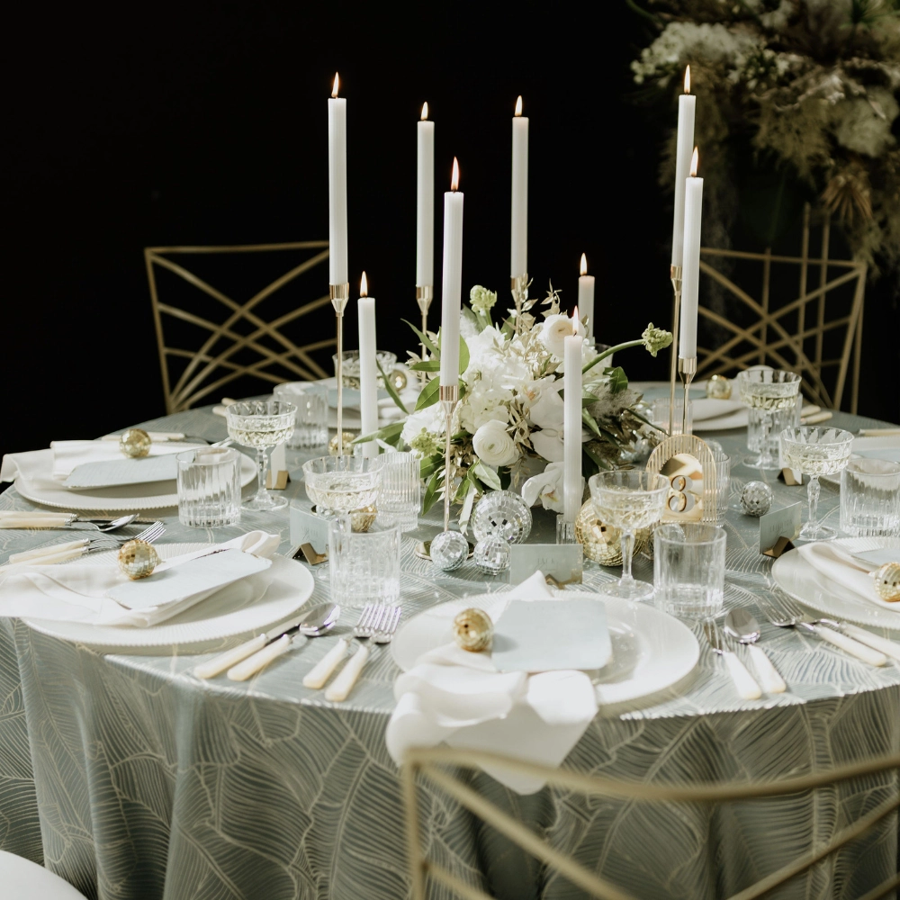A beautifully adorned table set with candles and flowers, available for event linen rental.