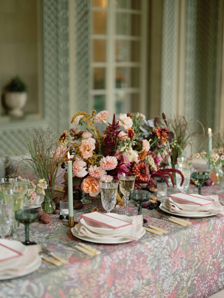 A table set with beautiful flowers and elegant glasses adorned with rented table linens for an exquisite event.