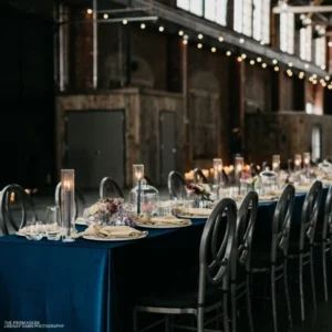A long table set for a dinner party with Montana Suede Navy event linen rental.