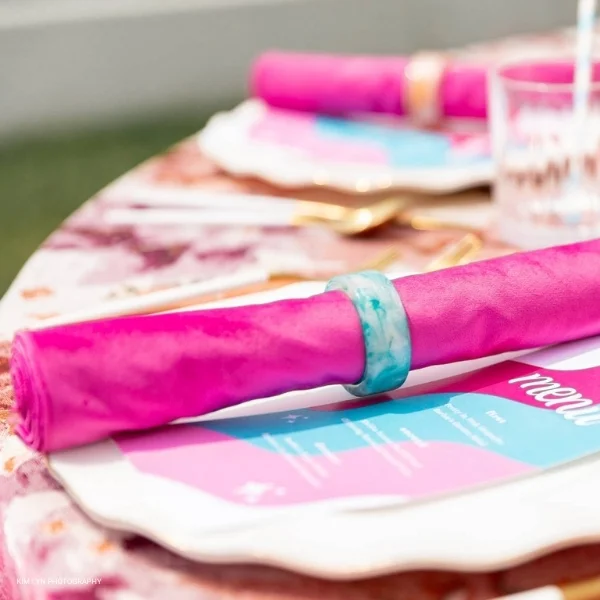 An elegant table setting with Velvet Magenta napkins available for table linen rental.