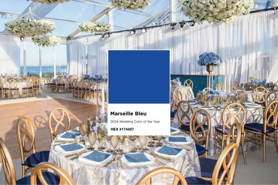 A wedding reception setup features tables with blue and gold decor, centered around a swatch labeled "Marseille Bleu, 2024 Wedding Color of the Year, HEX #174487," with exquisite tablecloth rentals enhancing the elegant ambiance.