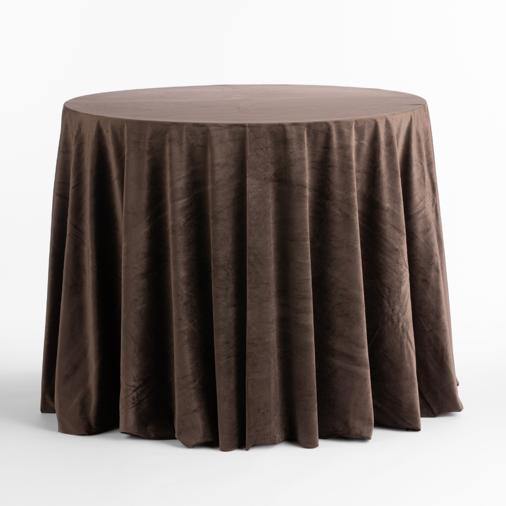 Round table adorned with a Cafe Noir Velvet brown, draped tablecloth on a white background.