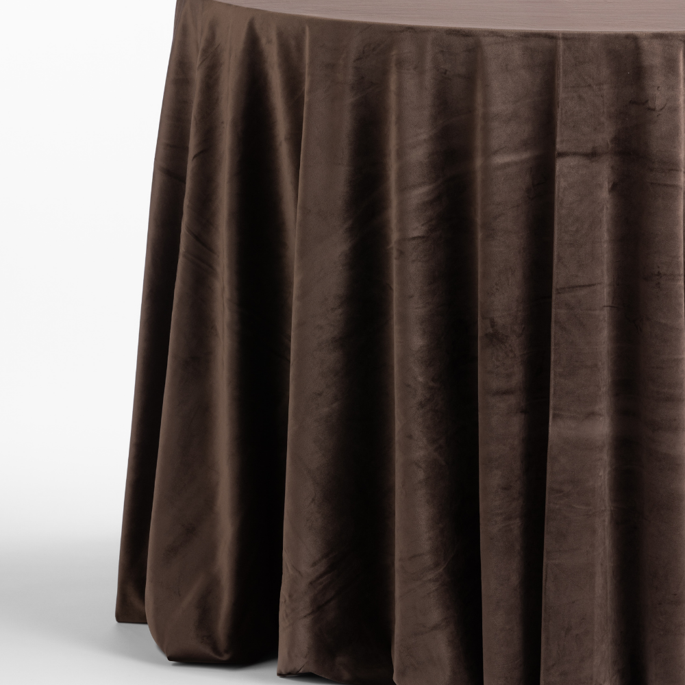 A round table covered with a long Cafe Noir Velvet tablecloth.