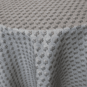 Close-up of a Rustic Moss Plaid tablecloth featuring a gray background adorned with a repeating pattern of small, white and green floral designs.