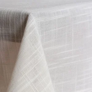 Close-up of a corner of a table adorned with the Azores, a textured beige tablecloth featuring a subtle crisscross pattern.