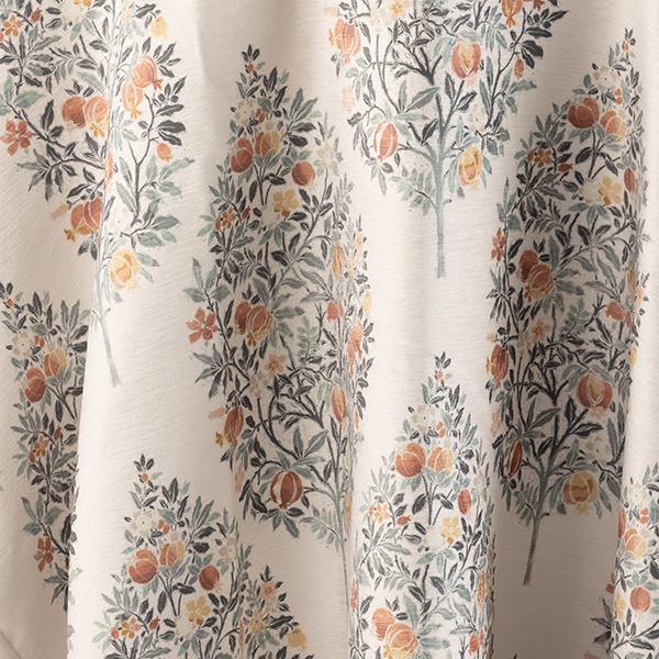 Fabric with a pattern featuring symmetrical trees filled with orange, yellow, and green elements.