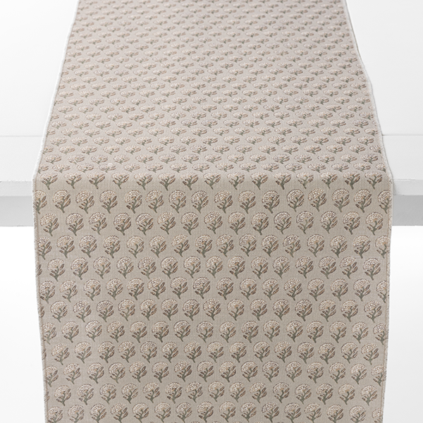 Table runner with a beige background, featuring a repetitive pattern of small, stylized trees.