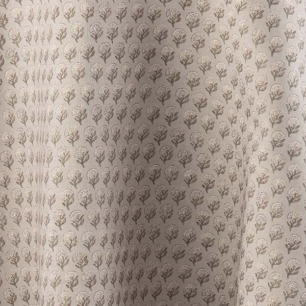 Close-up of a beige curtain featuring a repetitive pattern of small, ornate tree-like designs.