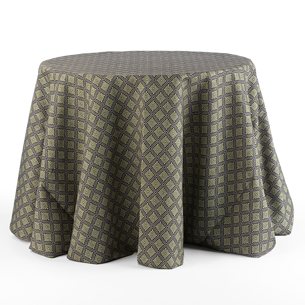 A round table is covered with a dark-colored, patterned tablecloth featuring a geometric diamond design.