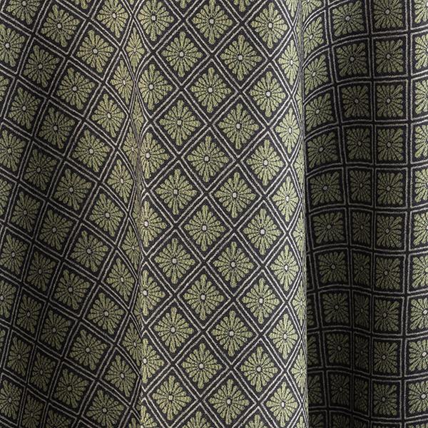 Close-up of fabric with a diamond pattern, each containing a small floral design, in shades of green and black.