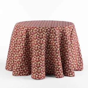 A round table covered with a red, white, and green floral patterned tablecloth against a plain white background.