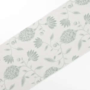 A piece of fabric with a light gray background featuring a pattern of green floral designs and leaves.