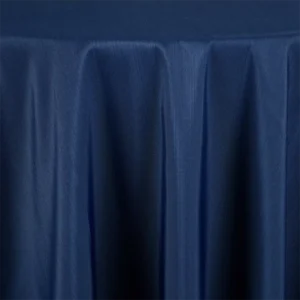 The Monaco Navy draped tablecloth, featuring a slightly glossy texture, covers a round table.