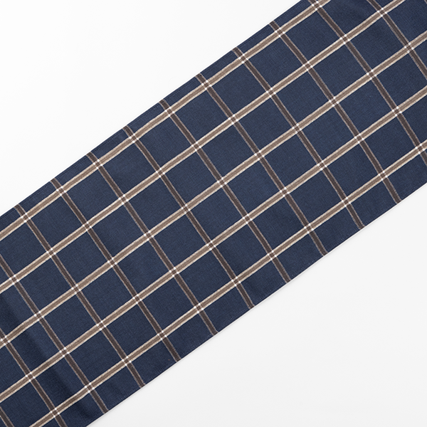 A close-up of a rectangular piece of fabric featuring a blue and brown plaid pattern.