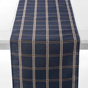 A navy blue table runner with a beige and white plaid pattern is draped over a white table.