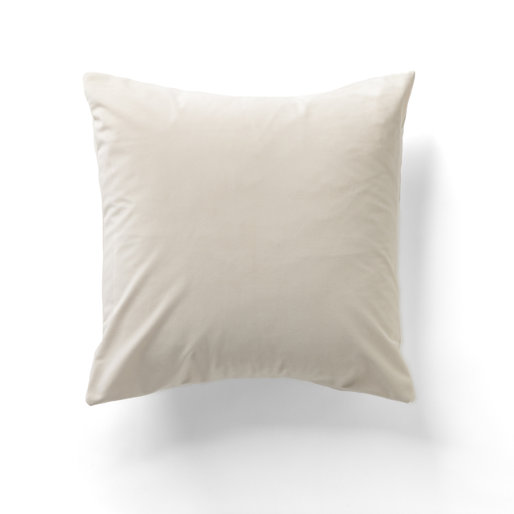 The Cafe Noir Velvet Pillow, in a light beige hue, is displayed against a white background.