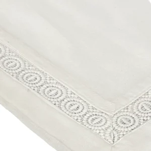 Close-up of the Cora White Napkin, showcasing an embroidered decorative border with a circular pattern.