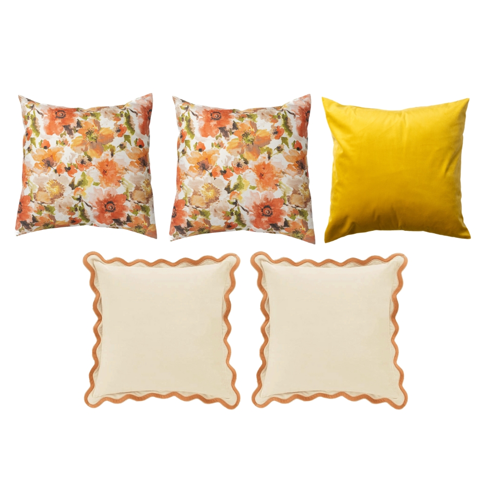 Five throw pillows: three with floral patterns, one in solid yellow, and two in beige with orange wavy borders.