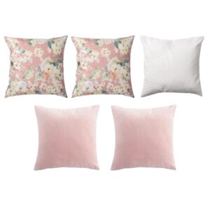 Five decorative pillows; three with floral patterns on pink backgrounds and two in solid pale pink.