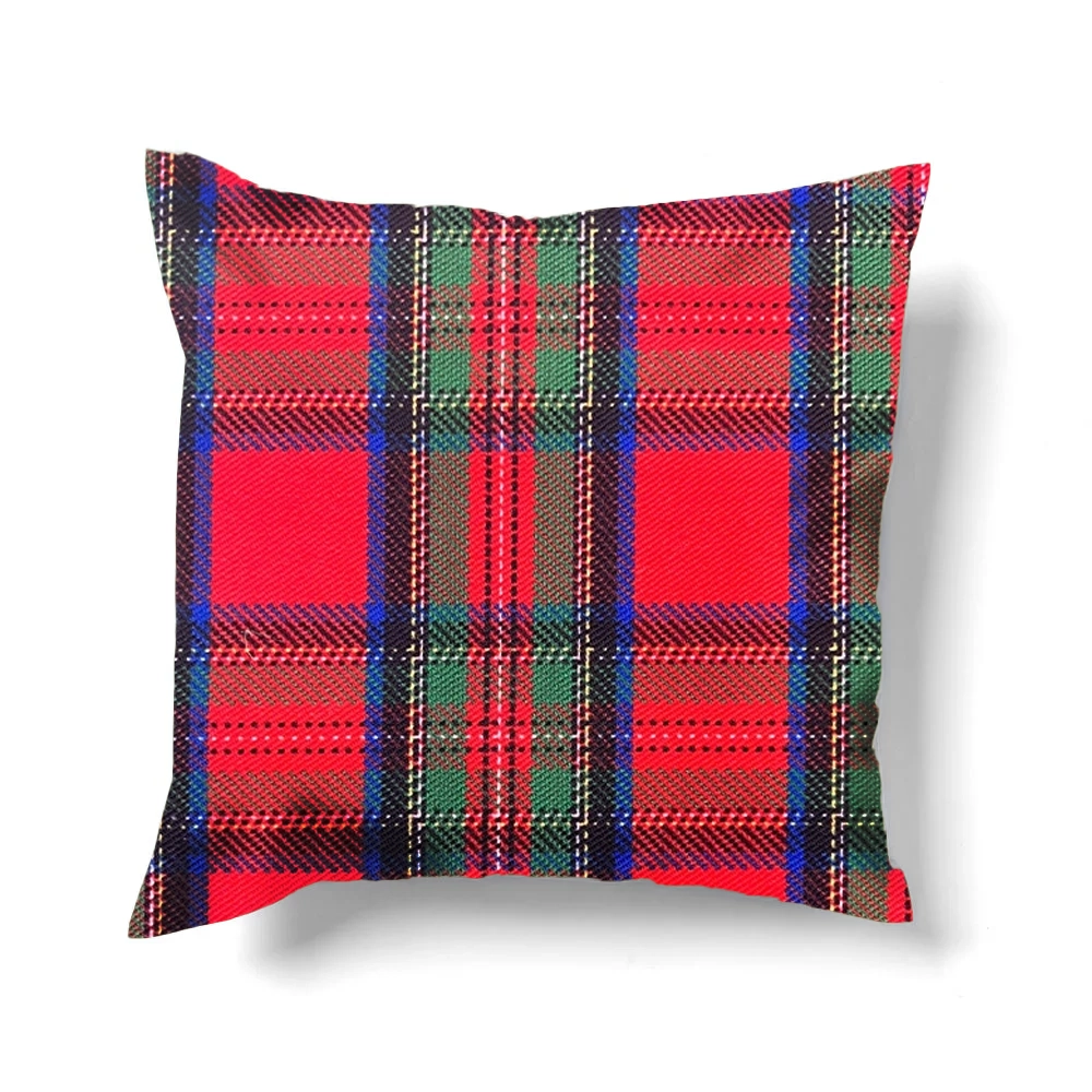 A square pillow featuring a tartan plaid holly berry pattern in red, green, and blue.