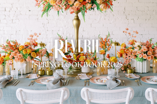 Elegant spring table setting with floral arrangements, gold accents, and striped napkins on plates, enhanced by exquisite table linen rentals. A "Reverie Social Spring Look Book 2025" text overlay completes the charming scene.