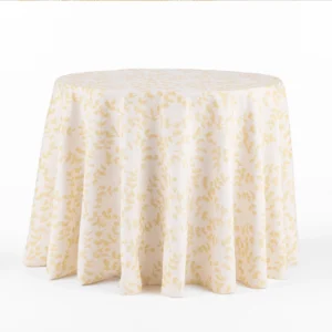 Round table adorned with the Westerly Dusty Rose tablecloth featuring a white and yellow floral pattern, set against a plain background.